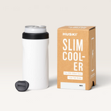 Huski Slim Can Cooler in white with black rim and detachable black Can Tab Slider, made of stainless steel with silicone base next to its cardboard box.