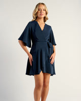 Woman wearing a navy blue dress on a white background