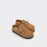 Pair of tan suede sandals with buckles on a light gray background