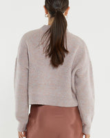 Back view of a pink marle wool-blend pointelle jumper with dropped shoulders and ribbed hem.