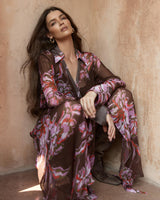 Model wearing a dark floral print wrap dress in sheer viscose with a collared neckline and self-tie waist detail.