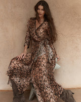 Model wearing a brown patterned Isla wrap dress with a collared neckline, long sleeves, and a self-tie waist detail.