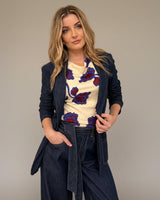 Jade Seamed Jersey Top with a cream and blue floral print, boat neckline, and gathered waist, worn under a denim blazer.