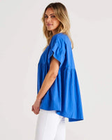 Bright blue 100% cotton Jameson blouse with a scoop neck, empire waist, and mini frill sleeves.