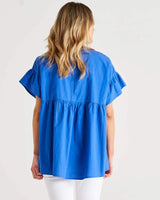 Back view of a blue 100% cotton Jameson blouse featuring a relaxed empire waist and mini frill sleeves.