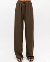 Olive green drawstring pants in a wide-leg cotton-nylon blend with an elastic waist and relaxed, flowing fit.