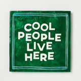 Green square sign with 'Cool People Live Here' text on a white background