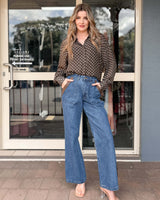 Woman wearing a brown long-sleeve Joy shirt with white polka dots, featuring a collared, button-through relaxed viscose fit.