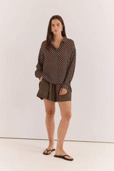 Relaxed fit long-sleeve Joy Shirt in brown with white polka dots, featuring a collared button-down design.