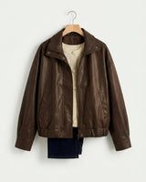 Dark brown leather-look bomber jacket with a high neck, metal zip, snap closures, and a relaxed dropped-shoulder fit.