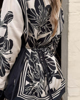 June Collared Shirt in black and white floral print with contrast trim and an adjustable back waist tie.