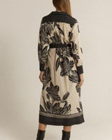 Back view of a beige midi shirt dress with a black floral print, classic collar, and contrast trim details.