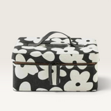Kip & Co structured cotton canvas toiletry case in black with a bold white flower print and black leather handle.
