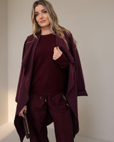 Woman wearing a relaxed-fit wine colored coatigan with an open front and soft knit texture.