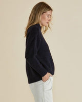 Woman wearing a navy blue mock neck knit jumper with ribbed cuffs and hem in a relaxed, soft stretch fit.