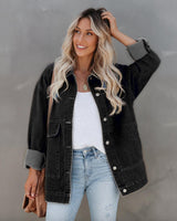 Charcoal hip-length cotton denim jacket with front button closure and side pockets worn over a white top.