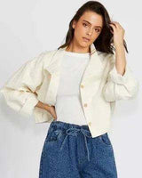 Cream-colored 100% cotton Lori jacket with a button-front design and relaxed fit, worn over a white top.