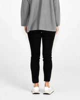 Back view of Luella black super stretch jeans with a sleek, mock-pocket design paired with a grey top and white sneakers.
