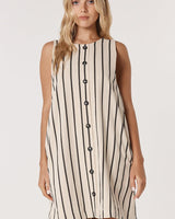 Beige shift dress with black vertical stripes, featuring a functional button-front closure and sleeveless design.