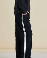 Black Maddison joggers with a relaxed fit, side pockets, and white vertical stripe detailing down the leg.