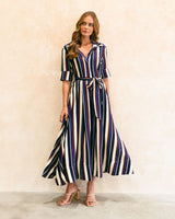 Midnight Morsel midi dress featuring a navy, burgundy, and white vertical stripe pattern with a waist tie and collar.