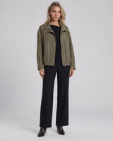 Olive green Murphy bomber jacket with a zip front, silver snap details, and an elasticated hem worn over black trousers.