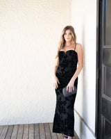 Elegant black burnout floral maxi dress with adjustable spaghetti straps and front ruching for a formal event.