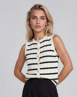 Model wearing a black and white striped cotton knit vest with a button-through front and textured rib detailing.