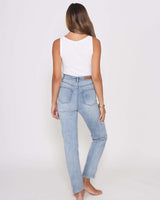 Back view of a woman wearing high-rise, light blue relaxed-fit Olivia mom jeans with a white tank top.