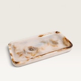House of Holabox Ophelia rectangular resin serving tray in a pearl finish with brown marbled accents and raised edges.