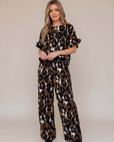 Woman wearing a leopard print outfit on a plain background