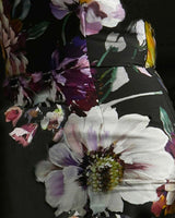 Providence dress in a black cotton-nylon blend featuring a bold, colorful floral print with large white and purple blooms.