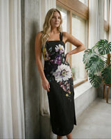 Model wearing a black cotton-nylon Providence midi dress with a square neckline and bold floral print.