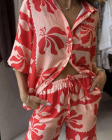Woman wearing a relaxed-fit, red and pink floral print Tencel-viscose resort pant set with a button-down shirt.