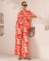Model wearing a relaxed-fit red and peach floral print Tencel-viscose resort pant set with a button-down shirt.