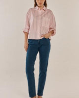 Model wearing Rita Relax Skinny dark blue stretch denim jeans paired with a pink striped button-down shirt.