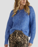 Model wearing a fluffy, oversized blue cardigan with a round ribbed neckline and front button closure.