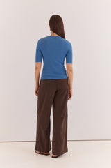 Blue Lilee Rib Knit top with short sleeves and a fitted ribbed texture, worn with brown trousers.