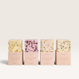 House of Holabox Soaked Body Bar luxe bath bombs in four assorted floral and botanical scents with pastel packaging.