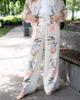 Wide-leg viscose-linen pants featuring an exclusive floral print and contrast border hem in a soft cream palette.