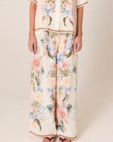 Wide-leg Solara pants in a cream viscose-linen blend featuring an exclusive floral print and contrast border hem.