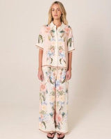 Wide-leg Solara pants in a cream floral print with a contrast border hem, crafted from a viscose and linen blend.