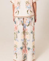 Wide-leg Solara pants in a floral print with contrast border hem, crafted from a beige viscose and linen blend.