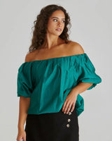 Emerald green off-shoulder top with elasticated neckline, voluminous bubble sleeves, and a soft hem.