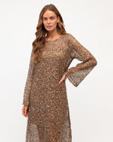 Model wearing a cocoa-toned open weave mesh dress with shimmering sequins and long sleeves.
