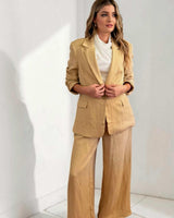 Woman wearing a relaxed-fit, tan drapey Sutton blazer with functional pockets and matching wide-leg trousers.