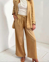 Tan Sutton wide-leg pants with an elasticated drawstring waist and side pockets, styled in a soft, drapey fabric.
