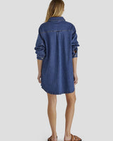Back view of a blue denim shacket dress with long sleeves, a collared neckline, and a curved hemline.