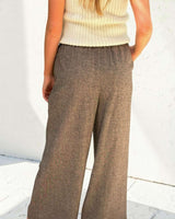 Back view of brown wool-blend wide-leg pull-on pants with an elasticated waistband and side pockets.