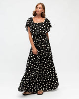 Model wearing a black and white polka dot off-shoulder rayon maxi dress with a flowing, tiered silhouette.